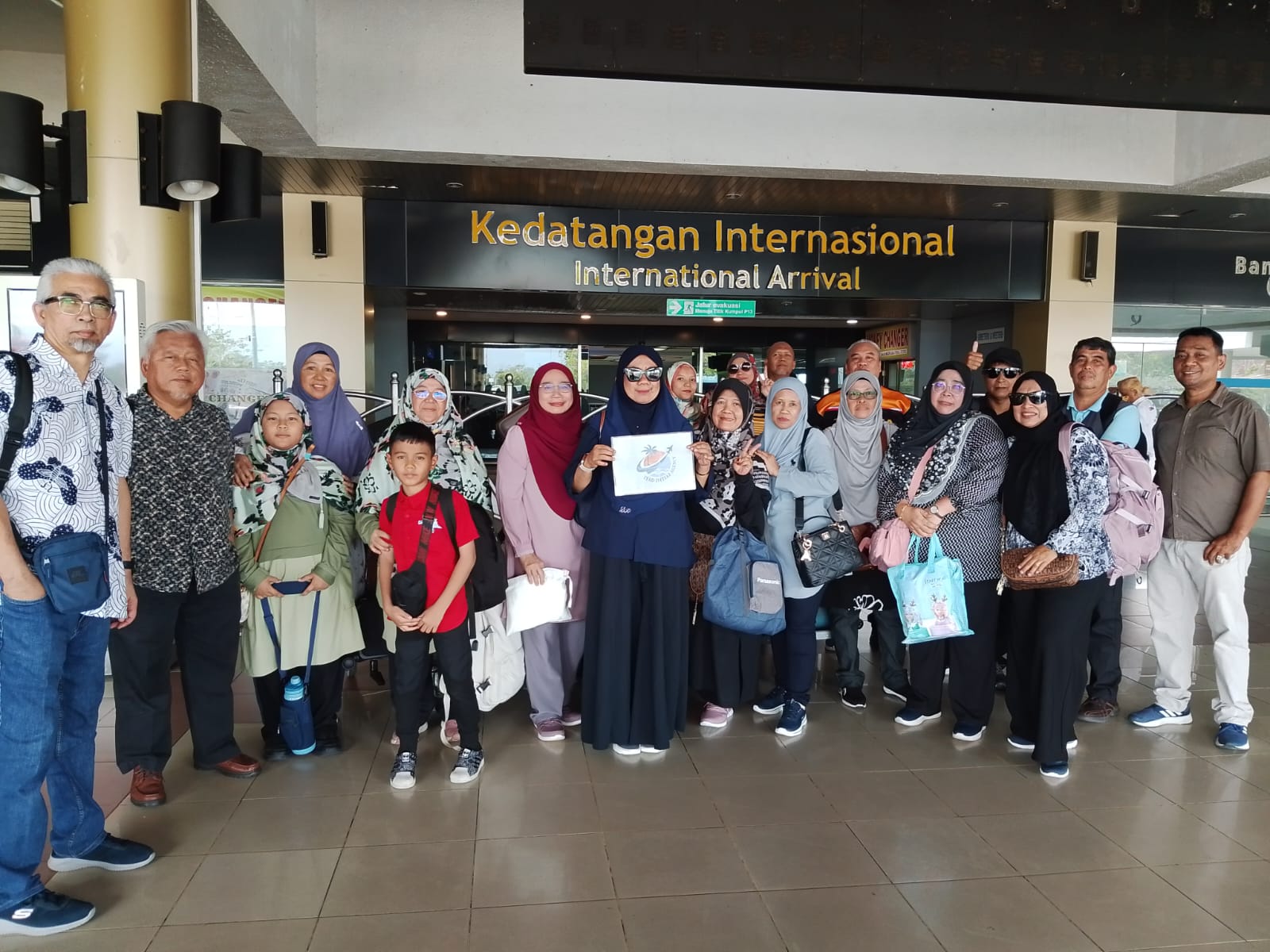 Rombongan berkumpul di kawasan ketibaan lapangan terbang.